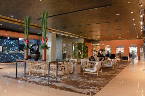 a lobby with chairs and tables in a building at ARTOTEL Suites Bianti Yogyakarta, CHSE Certified in Yogyakarta