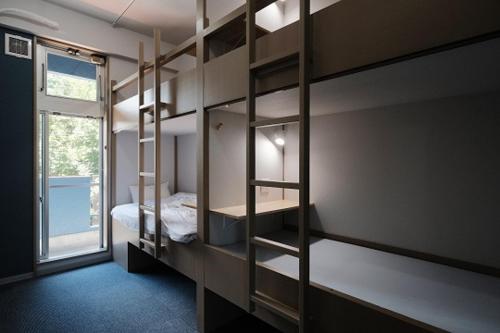 a room with three bunk beds and a window at 松代棚田ハウス 