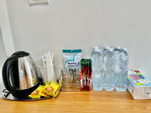 a counter top with bottles of water and a kettle at บ้านคุณย่า in Rayong