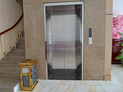 a metal elevator in a building with a staircase at Victoria Phu Quoc hotel 1 minute walking to beach, near to night market in Phú Quốc