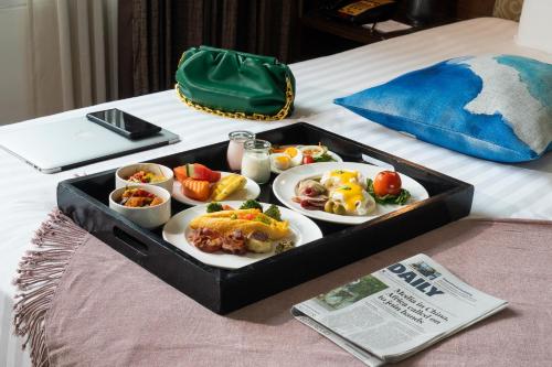 a tray of food on a bed with food on it at Park Plaza Sukhumvit Bangkok in Bangkok