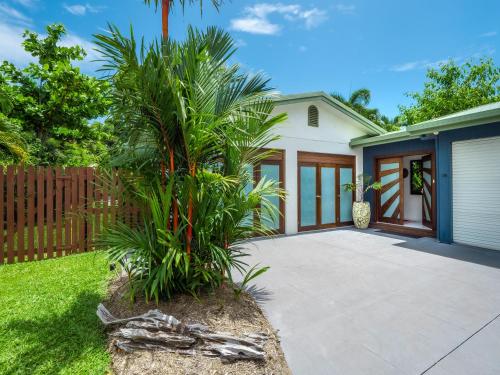 a palm tree in front of a house at Mango Wood Villa Tropical Coastal living in Clifton Beach