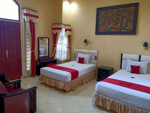 RedDoorz @ Puncak Tahura Hotel Bengkulu Tengah في بنجكولو: غرفة فندقية بسريرين ومرآة