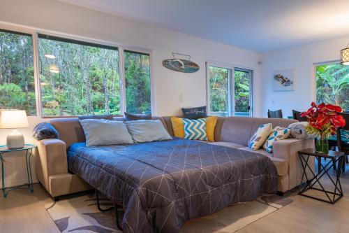 a living room with a couch and some windows at Mauna Ua in Volcano