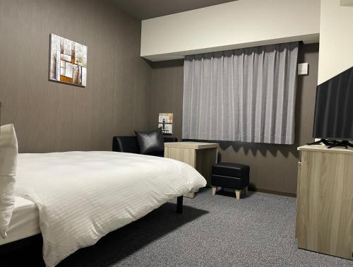 Hotel Route Inn Shikoku Chuo tesisinde bir odada yatak veya yataklar