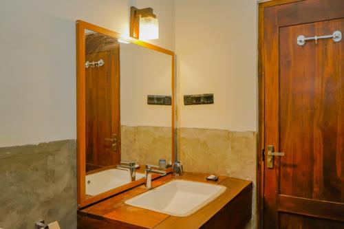 a bathroom with a sink and a large mirror at Athena Lake in Dambulla