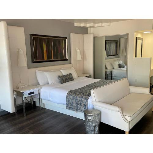 una habitación de hotel con una cama grande y una silla en Oak Tree Inn en Los Ángeles
