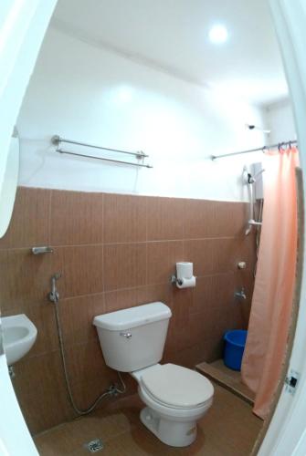 a bathroom with a toilet and a sink and a shower at Amor's Place in Puerto Princesa City