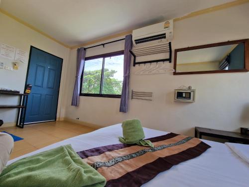 a bedroom with a bed and a window and a mirror at Lemonade Boutique Inn in Ko Lanta