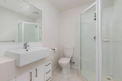a bathroom with a toilet and a sink and a shower at Astral Apartments. Spacious 2 bed, 2 bath apartment in a great location. in Melbourne