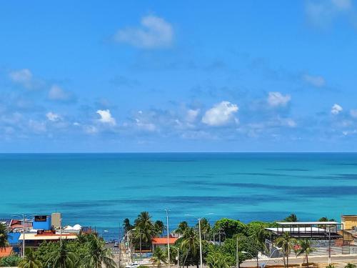 uma vista para o oceano a partir de um resort em Ilusion Flats Aconchego de Ponta Negra em Natal