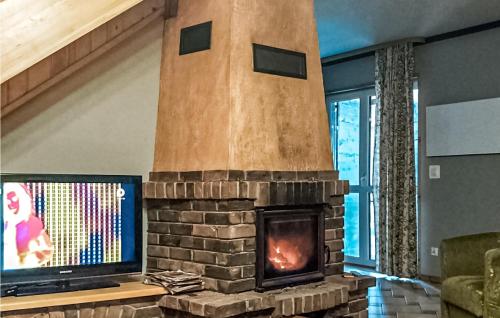 a fireplace in a living room with a tv at Nice Home In Pasym With Lake View in Pasym