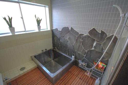 Hai Lodge في Otari: حمام مع حوض في غرفة مع نافذة