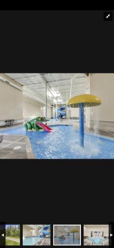 a pool with a yellow and red object in a building at Canmore Mountain Retreat. Hot Tub, Pool, King Bed! in Canmore