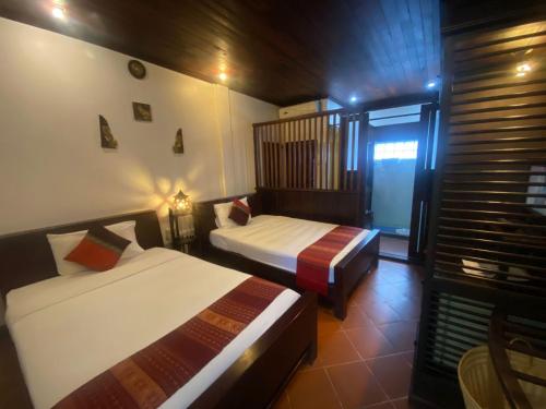 Postel nebo postele na pokoji v ubytování Vangsavath Hotel