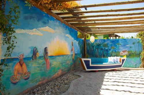 a wall with a couch in front of a mural at Milagres de Minas in São Miguel dos Milagres