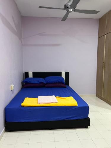 a bedroom with a blue bed with a ceiling at Batu Feringgi Homestay in Batu Ferringhi