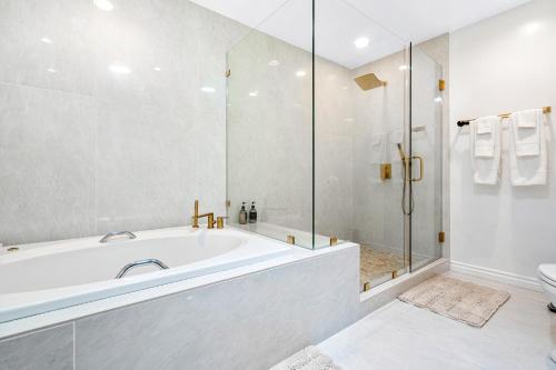 uma casa de banho branca com uma banheira e um chuveiro em Malibu Oasis em Malibu