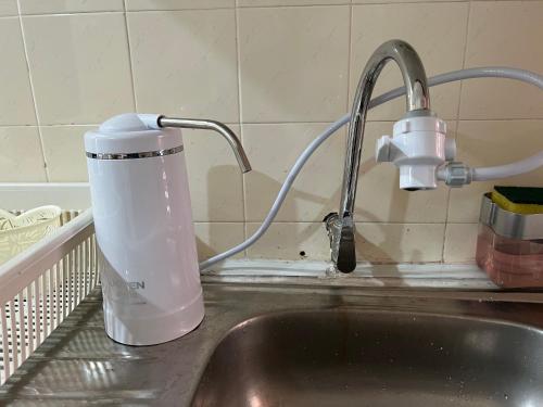 a kitchen sink with a water pitcher and a faucet at Batu Feringgi Homestay in Batu Ferringhi