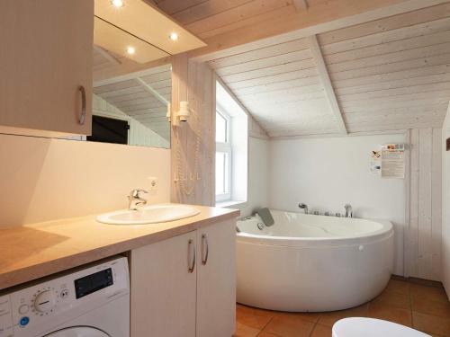 y baño con bañera, lavamanos y bañera. en Three-Bedroom Holiday home in Grömitz 20, en Grömitz