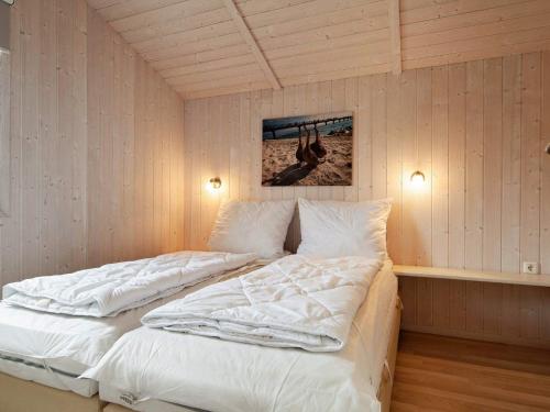 Schlafzimmer mit einem Bett mit weißer Bettwäsche in der Unterkunft Three-Bedroom Holiday home in Grömitz 20 in Grömitz