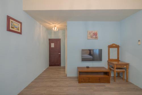 einen Flur mit einem Tisch, einem TV und einem Stuhl in der Unterkunft 桔子圓包棟民宿 小團體包棟 tesla 充電 in Taitung