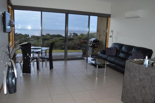 a living room with a black leather couch and a table at Rocky Cape Retreat in Rocky Cape
