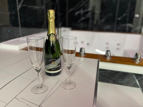 a bottle of champagne and two glasses on a table at Suite Élite in Catania