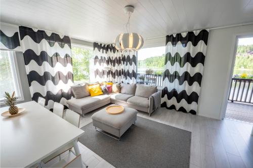 uma sala de estar com um sofá e uma mesa em Lake Residence Ukkohalla em Hyrynsalmi