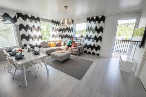 a person sitting on a couch in a living room at Lake Residence Ukkohalla in Hyrynsalmi