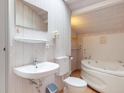 een badkamer met een wastafel, een toilet en een bad bij Three-Bedroom Holiday home in Grömitz 11 in Grömitz