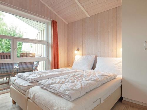 een slaapkamer met een bed en een groot raam bij Three-Bedroom Holiday home in Grömitz 11 in Grömitz