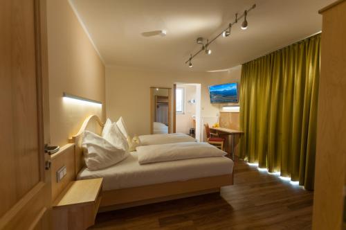 オイゲンドルフにあるGasthof Neuwirtのベッドとデスクが備わるホテルルームです。