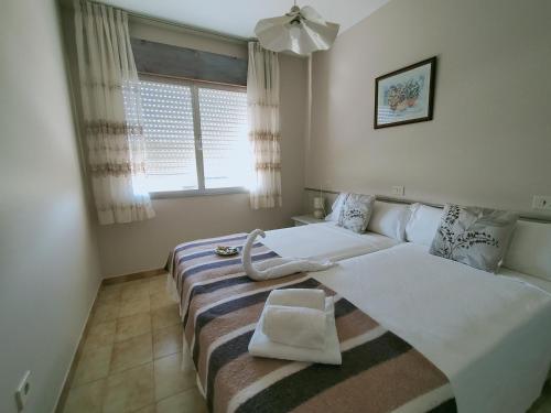 ein Hotelzimmer mit 2 Betten und einem Fenster in der Unterkunft CASA PORTELA APARTAMENTOS in Revolta