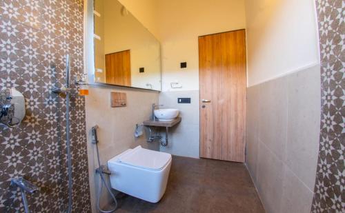 een badkamer met een toilet en een wastafel bij Touchwood Bliss Igatpuri in Nashik