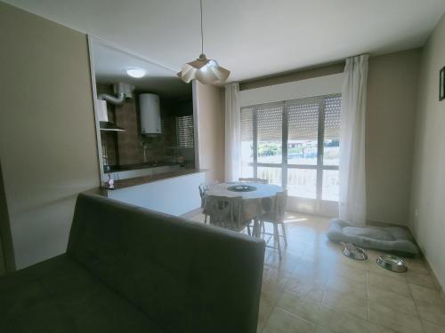 a living room with a table and a dining room at CASA PORTELA APARTAMENTOS in Revolta