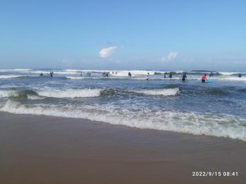 a group of people in the water at the beach at Devi Kripa Residency in Varkala