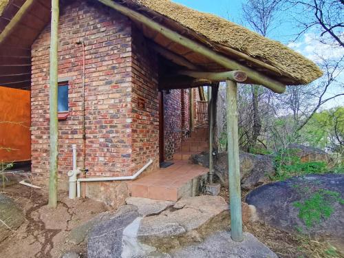 an outside view of a brick building with a staircase at Otters' Haunt Eco Retreat in Parys