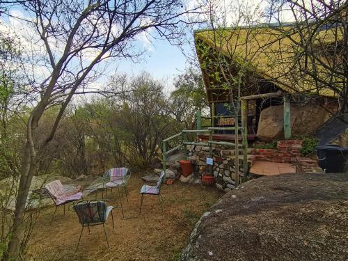a group of chairs sitting outside of a house at Otters' Haunt Eco Retreat in Parys