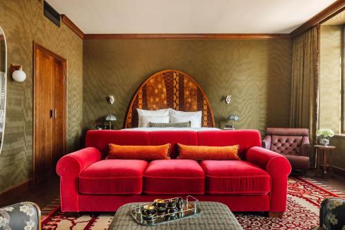 a living room with a red couch and a bed at Sommerro in Oslo