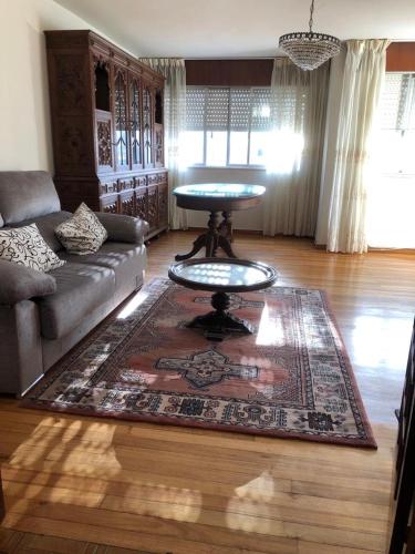 sala de estar con sofá y mesa sobre una alfombra en S lazaro, en Noia
