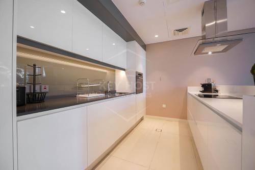 a kitchen with white cabinets and a counter top at KeyHost - Spectacular 2BR - Bluewaters Residences - Dubai - K240 in Dubai