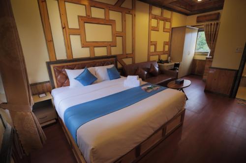 a bedroom with a large bed and a couch at Resort Hàng Dương in Blao Klong Ner