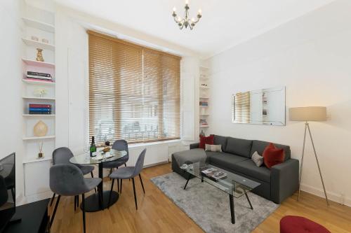 a living room with a couch and a table at Notting Hill Apartment Portobello Road, Hyde Park & Tube in London