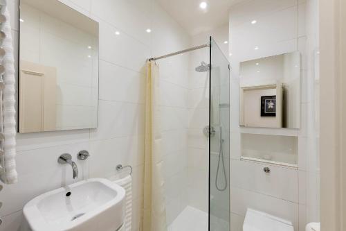 a white bathroom with a sink and a shower at Notting Hill Apartment in London