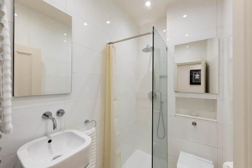 a white bathroom with a sink and a shower at Notting Hill Apartment Portobello Road, Hyde Park & Tube in London