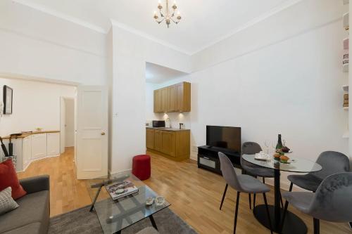 a living room with a couch and a table at Notting Hill Apartment Portobello Road, Hyde Park & Tube in London