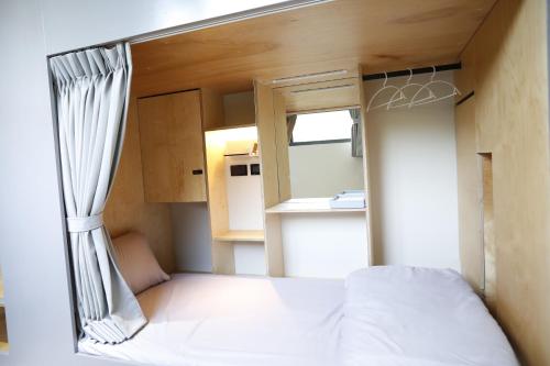 a small bedroom with a bed and a window at Walking Island in Xiaoliuqiu