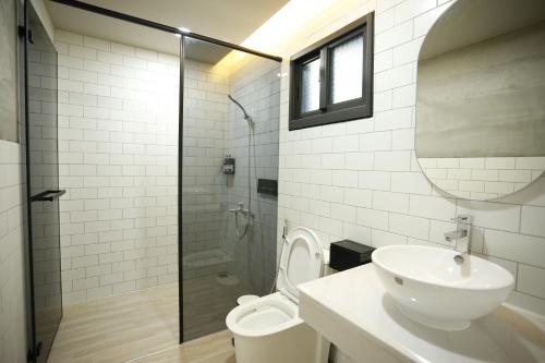 a bathroom with a toilet and a sink and a shower at Walking Island in Xiaoliuqiu