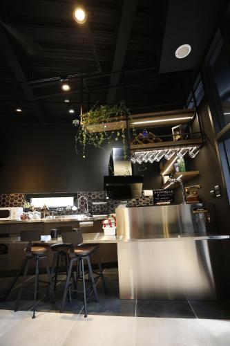 a kitchen with tables and stools in a restaurant at Walking Island in Xiaoliuqiu